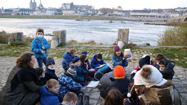 Des élèves sont assis sur les quais de la Loire, à Blois.